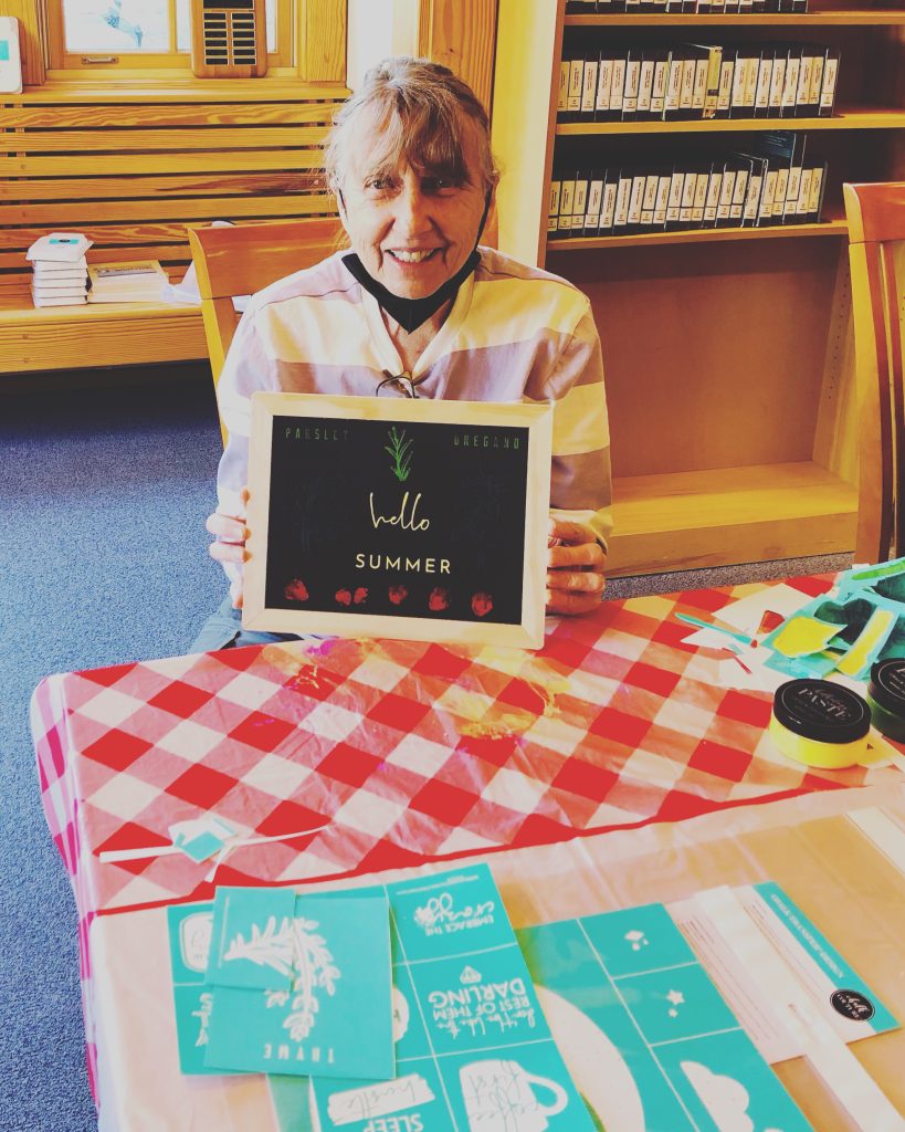 Local patron holds up a sign that she made at our Chalk Couture workshop. 